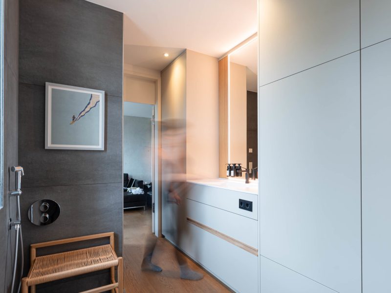 Moderne badkamer met op maat gemaakte inbouwkast en wastafel, persoon in beweging