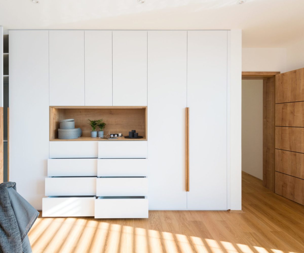 Witte houten kledingkast met open vakken in de slaapkamer van een modern huis