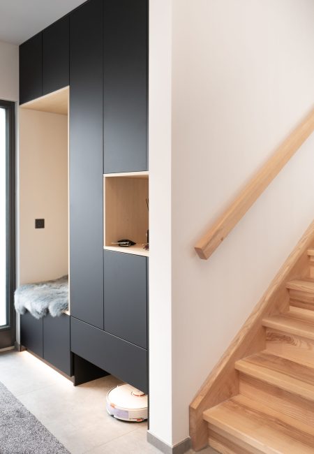 Zwarte garderobekasten met houten elementen en bank