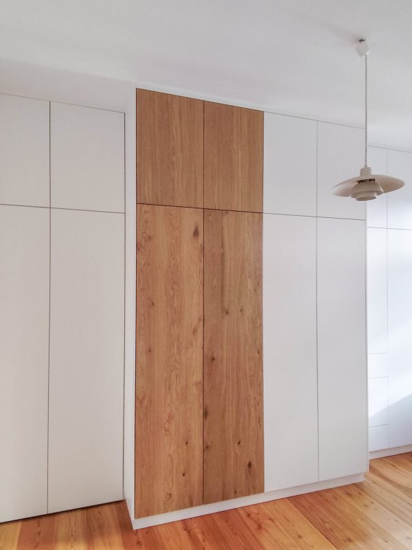 Op maat gemaakte inbouwkast in wit met een houten front in het midden in de slaapkamer