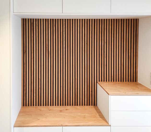 Weiße Garderobe mit Sitzbank und Holzpaneelen