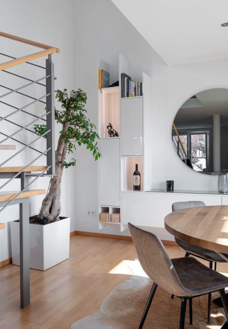 Witte, hoogglanzende wandmeubel in de open woonkamer