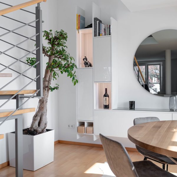 Witte, hoogglanzende wandmeubel in de open woonkamer
